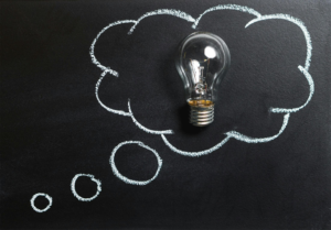 A clear light bulb placed on a chalkboard in a speech bubble